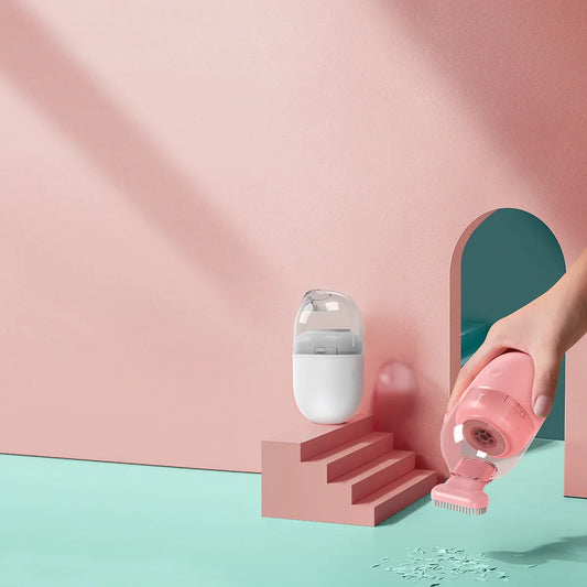 Pink handheld vacuum cleaner with brush attachment, compact design for easy cleaning, shown with charging dock on pastel background