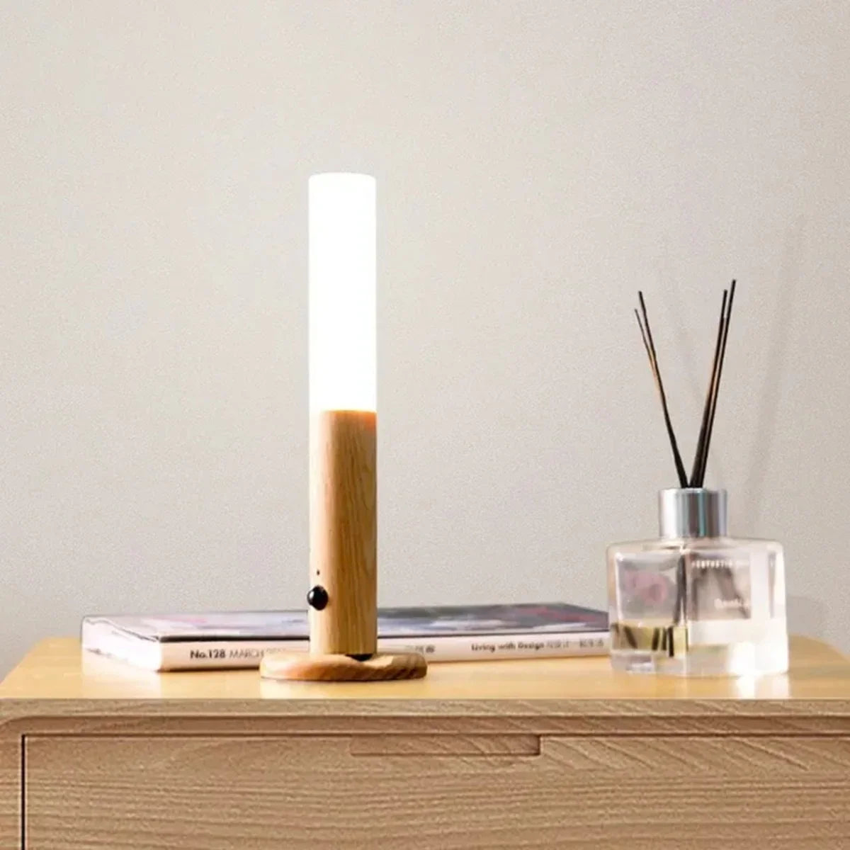 Modern wooden table lamp with soft glow, styled on a nightstand with books and reed diffuser