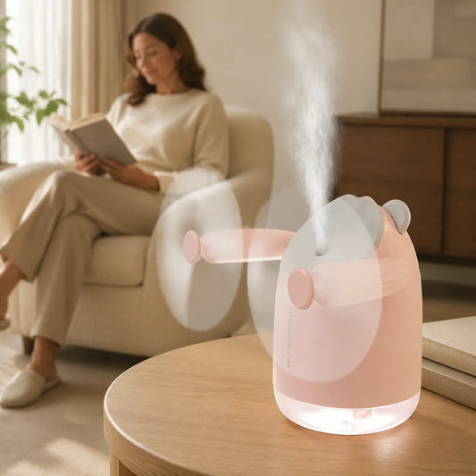 Pink InnoDeviceHub AeroMist 2-in-1 USB Humidifier Fan misting on a wooden table in a living room.