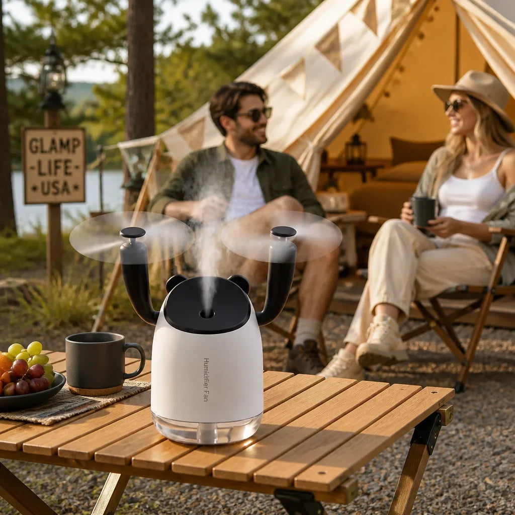 AeroMist 2-in-1 USB Humidifier Fan on a wooden table at a glamping site with a couple behind.
