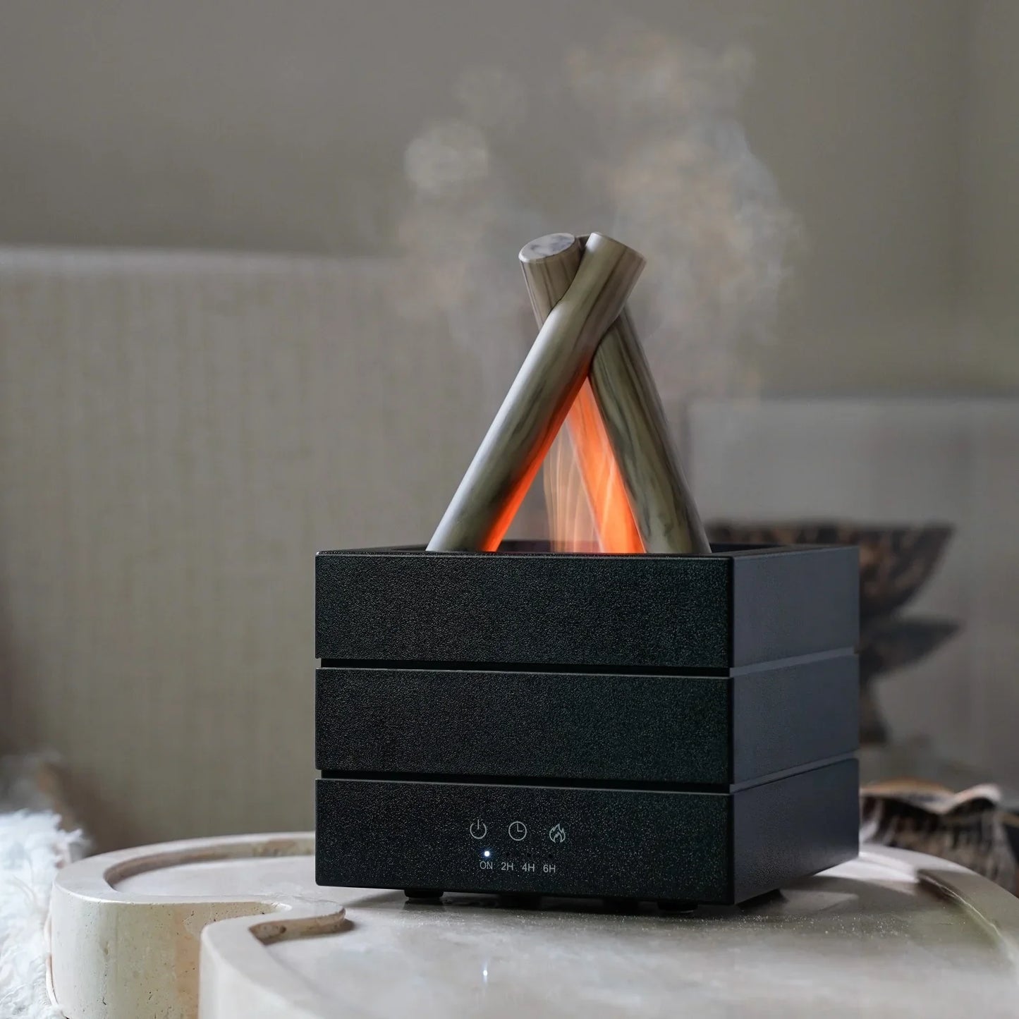 Modern black aroma diffuser with campfire design, emitting mist and warm glow, ideal for home relaxation and ambiance.